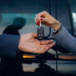 Woman give cars key to man. Hands hold car keys. Car rental